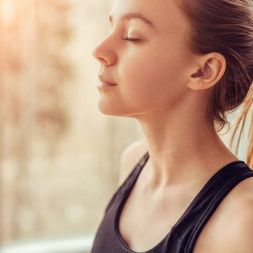 Woman soaking up the sun and looking calm and relaxed after a personalised wellbeing consultation